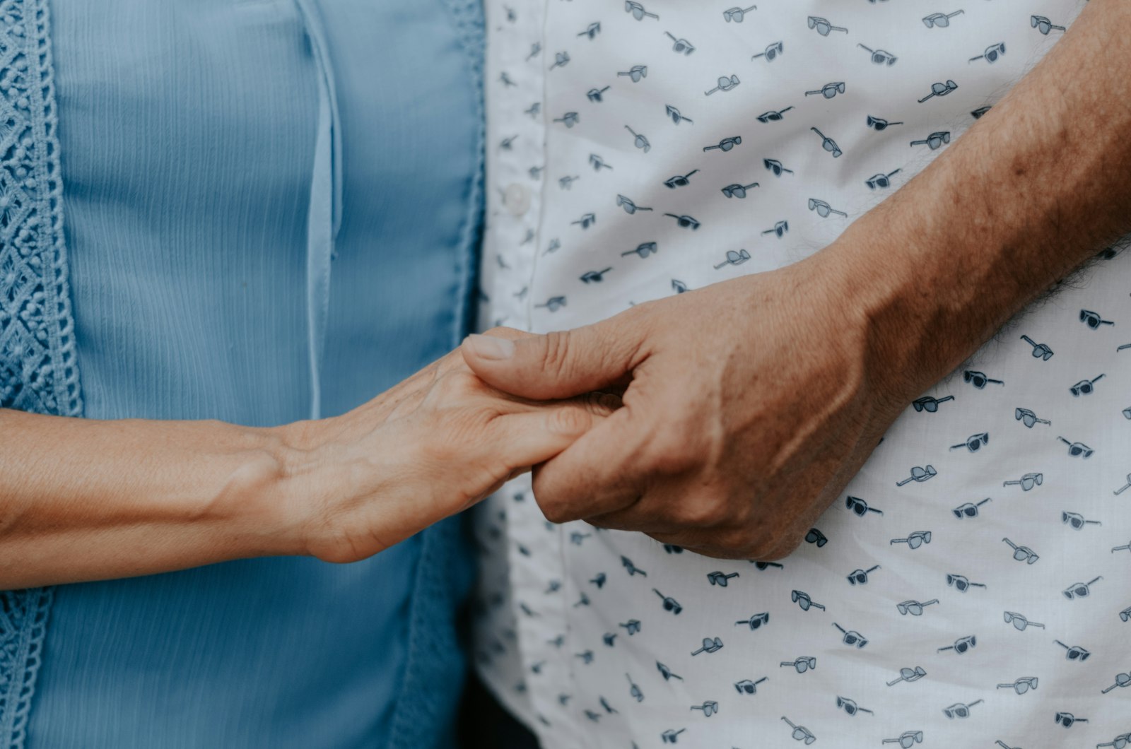 A younger hand holding an older person's hand