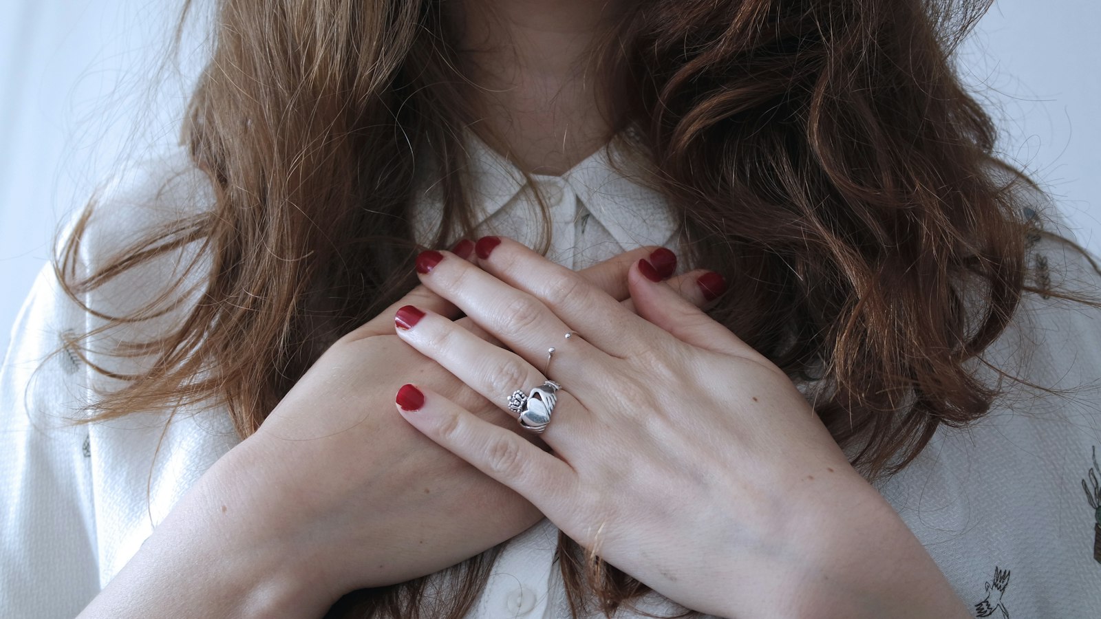 A woman resting both hands over her heart