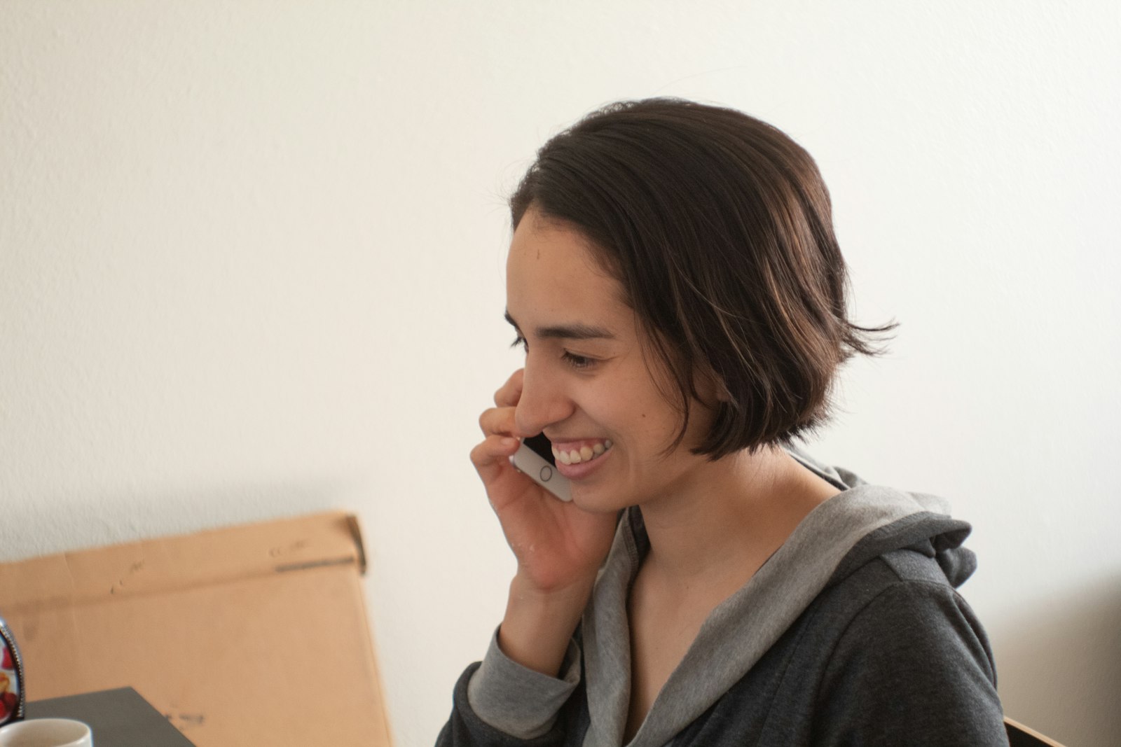 A woman smiling during a relaxed phone call at home