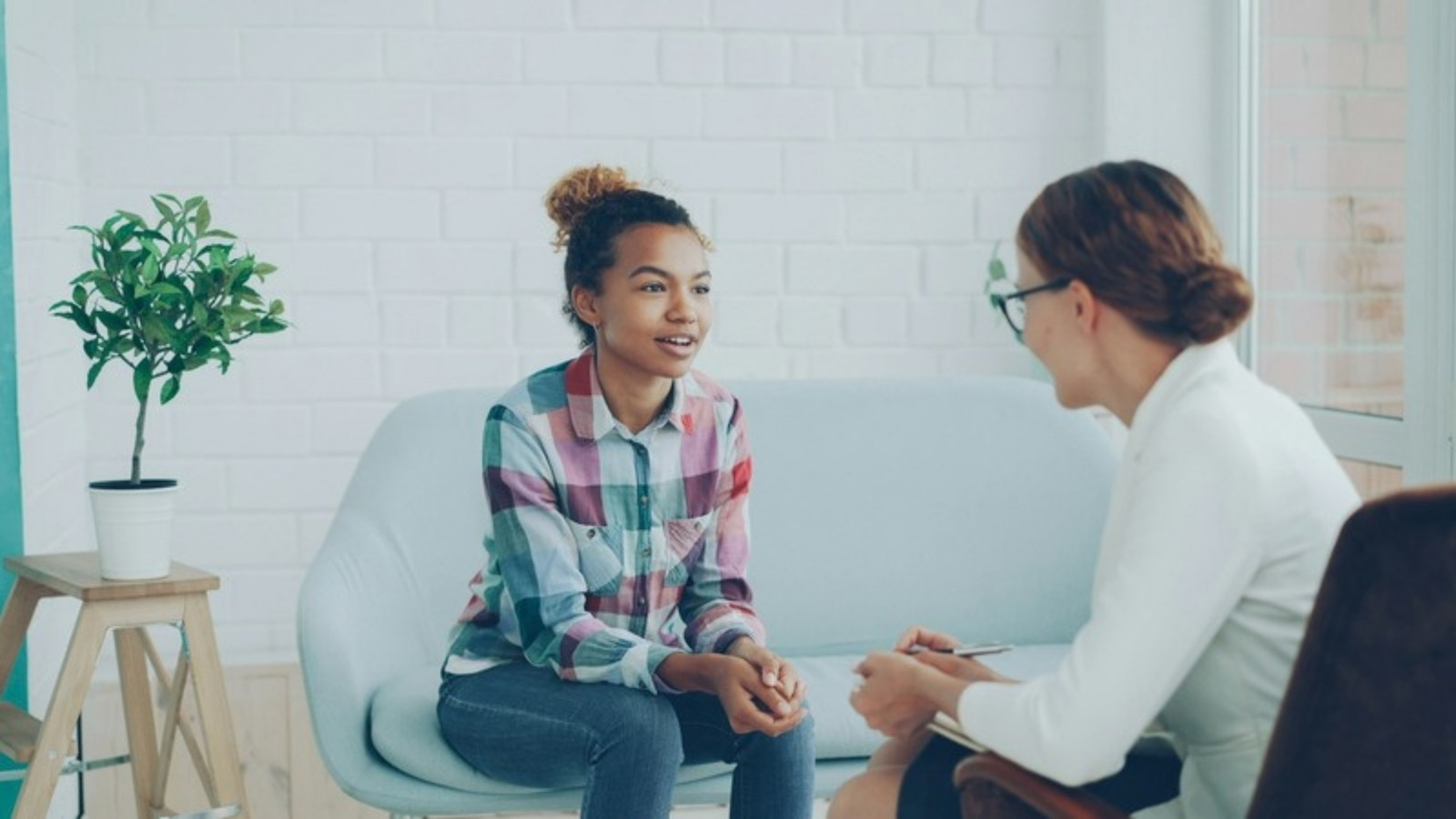 A client and psychologist talking in a bright, airy therapy office